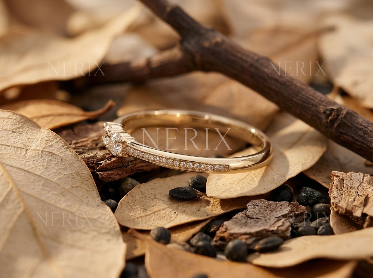 Dainty gold wedding band on autumn leaves